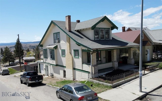 1100 Caledonia St, Butte, MT 59701 - view of front of home with a chimney, covered porch, a shingled roof, and a mountain view
