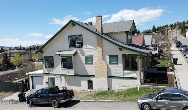 1100 Caledonia St, Butte, MT 59701 - view of front of home featuring a chimney, a garage, and cooling unit