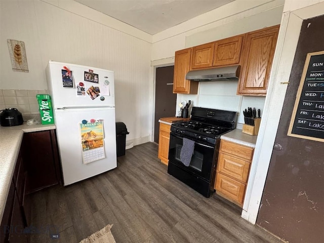 1100 Caledonia St, Butte, MT 59701 - kitchen with black gas range, freestanding refrigerator, under cabinet range hood, dark wood finished floors, and light countertops