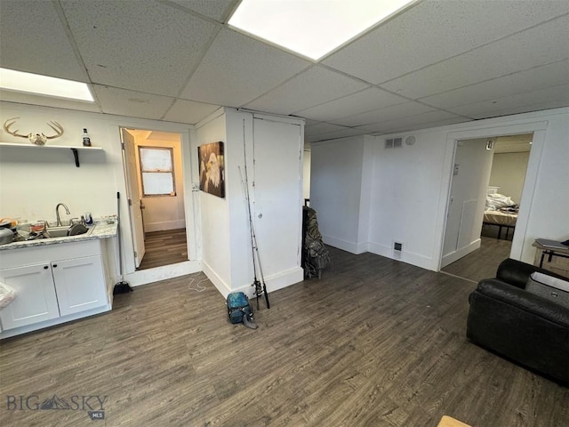 1100 Caledonia St, Butte, MT 59701 - finished below grade area with a paneled ceiling, dark wood finished floors, baseboards, and a sink