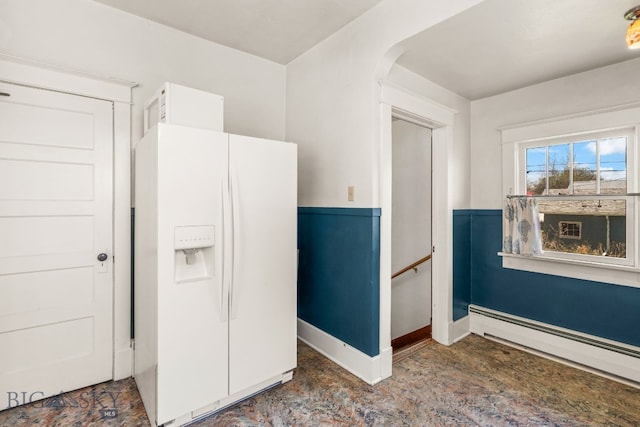 kitchen with white refrigerator with ice dispenser, baseboard heating, arched walkways, and white cabinets