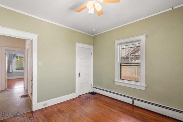 empty room with a baseboard radiator, ceiling fan, baseboards, wood-type flooring, and ornamental molding