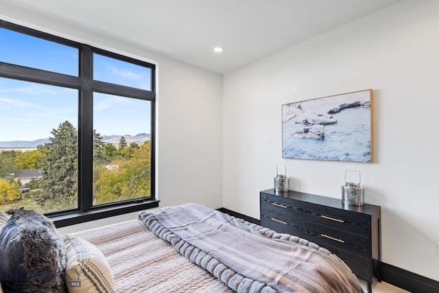 bedroom with baseboards, recessed lighting, and a mountain view