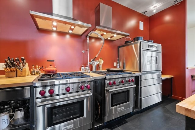 kitchen featuring appliances with stainless steel finishes, wall chimney range hood, island range hood, and beverage cooler