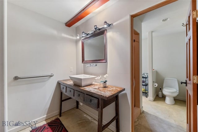 bathroom with vanity, toilet, and baseboards