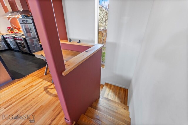stairs with wood finished floors and baseboards