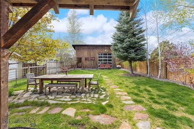 view of yard with outdoor dining space and an outbuilding