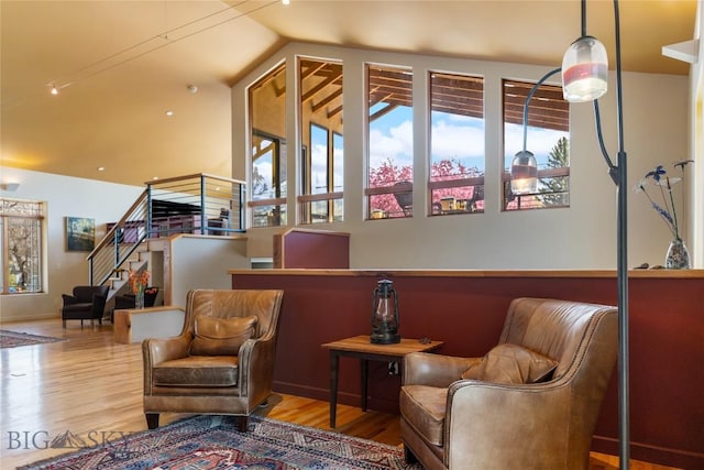 sitting room with wood finished floors, stairway, and lofted ceiling