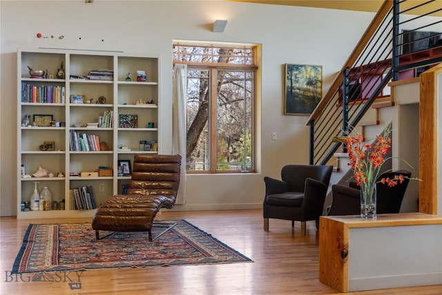 sitting room with baseboards, wood finished floors, and stairs