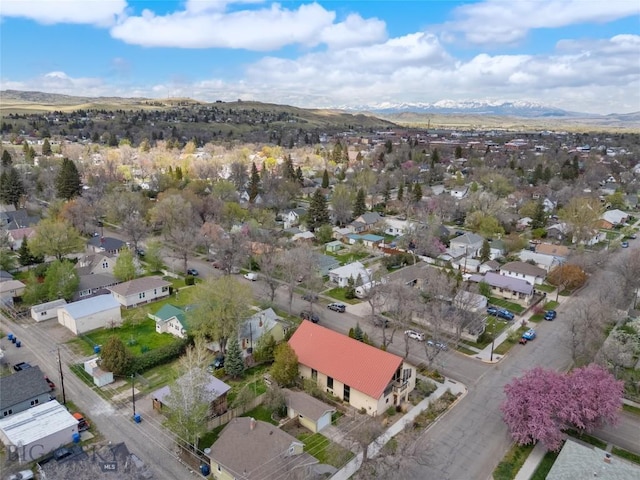 aerial view of property and surrounding area featuring nearby suburban area and a mountainous background