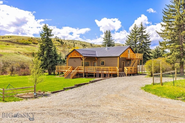 view of front of home featuring a deck with mountain view, stairway, and metal roof