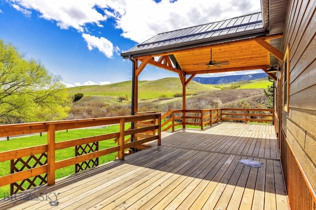 wooden deck featuring a ceiling fan and a mountain view