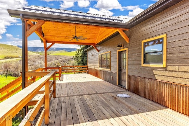wooden deck with a mountain view and a ceiling fan