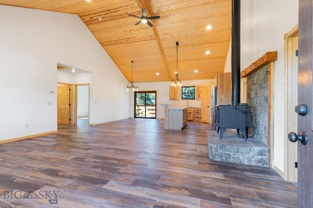 unfurnished living room featuring high vaulted ceiling, wooden ceiling, dark wood finished floors, a ceiling fan, and a wood stove