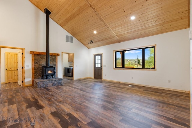 unfurnished living room featuring a wood stove, high vaulted ceiling, wood finished floors, washer / dryer, and wooden ceiling