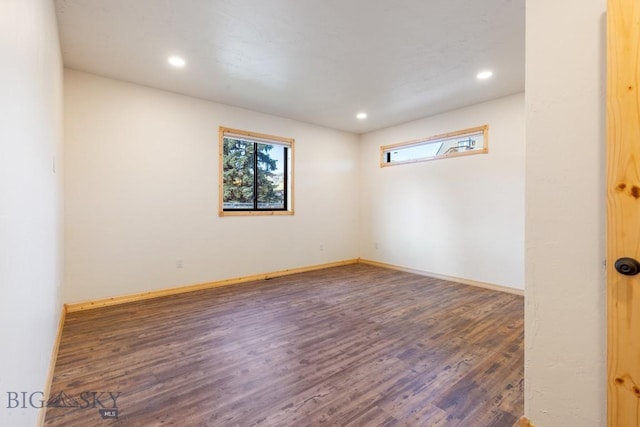 empty room with healthy amount of natural light, wood finished floors, recessed lighting, and baseboards