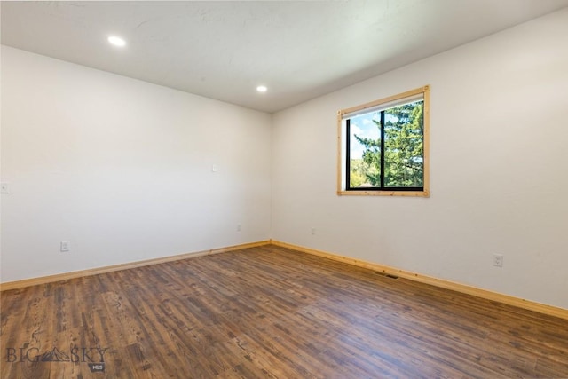 unfurnished room with wood finished floors, baseboards, and recessed lighting