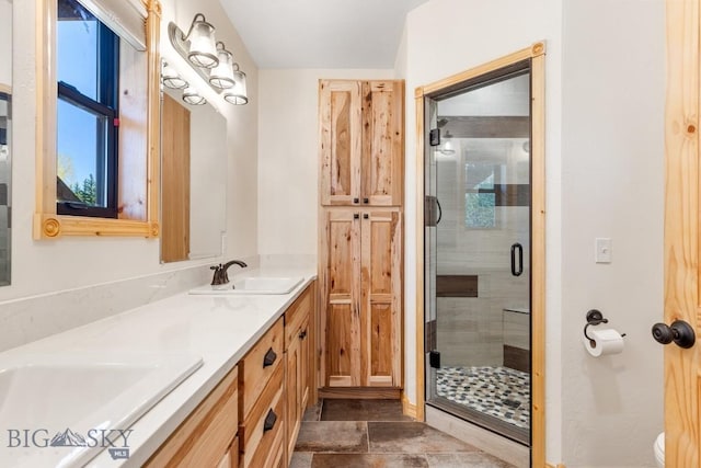 full bath featuring a shower stall, double vanity, and toilet