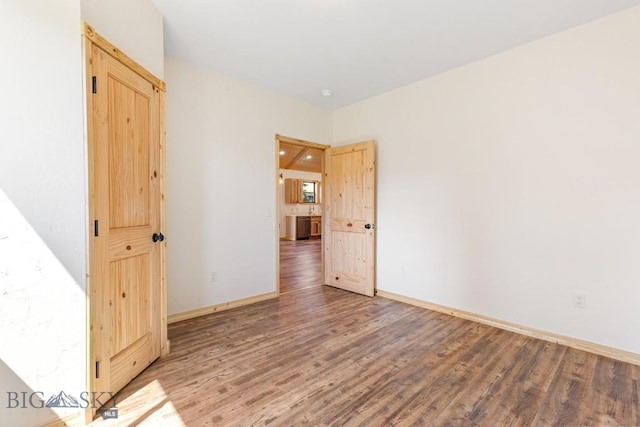 unfurnished room featuring wood finished floors and baseboards