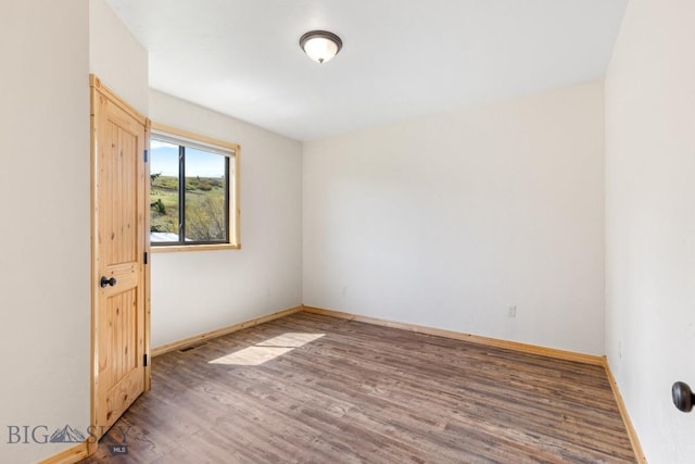 empty room with wood finished floors and baseboards