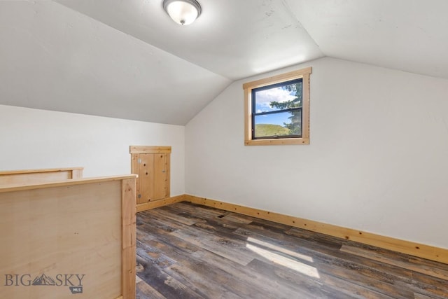 bonus room featuring vaulted ceiling, dark wood-type flooring, and baseboards