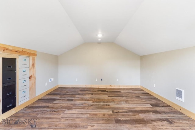bonus room with wood finished floors, vaulted ceiling, and baseboards