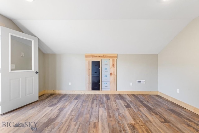 additional living space featuring vaulted ceiling, wood finished floors, and baseboards