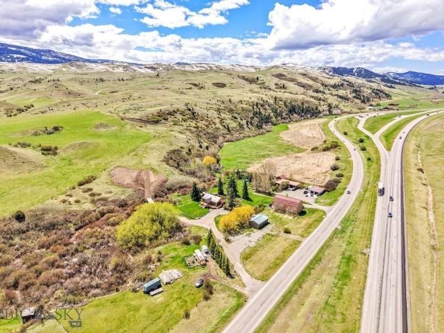 drone / aerial view of a mountain backdrop and a major roadway