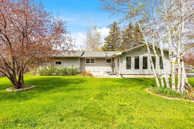 back of property featuring a yard