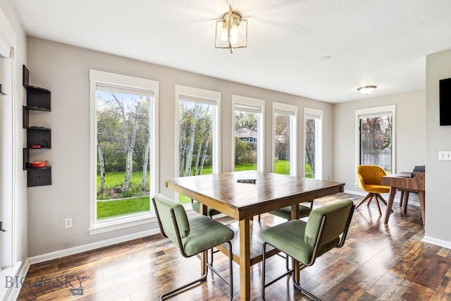 dining space with baseboards and dark wood finished floors