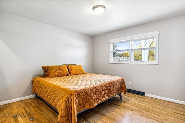 bedroom with wood-type flooring and baseboards