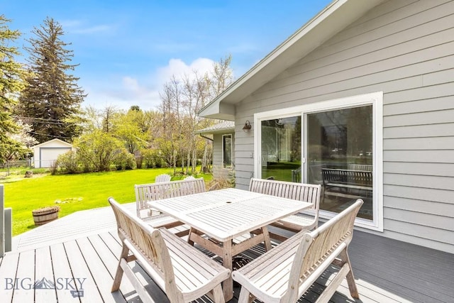 wooden terrace with outdoor dining area and a lawn