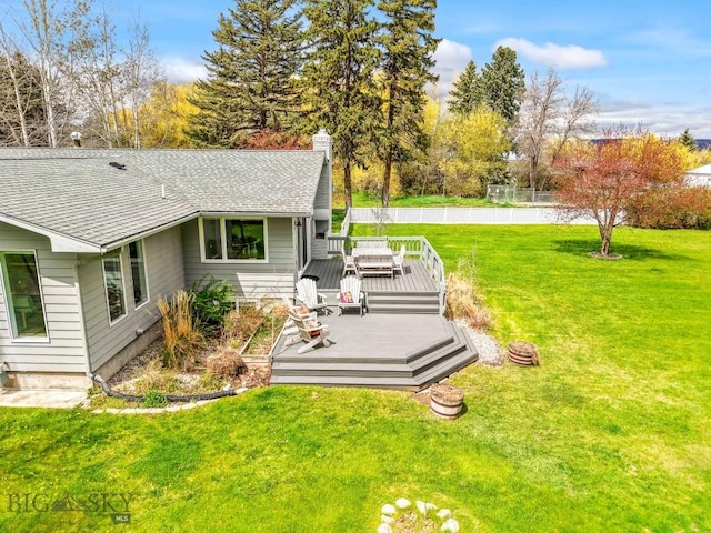 view of grassy yard with a deck