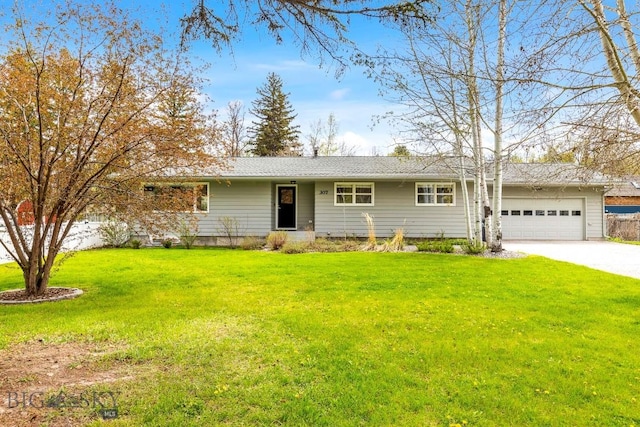ranch-style house featuring a garage, a front lawn, and driveway