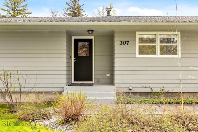 property entrance with roof with shingles