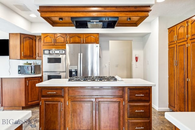 kitchen featuring stainless steel appliances, light countertops, brown cabinets, baseboards, and recessed lighting