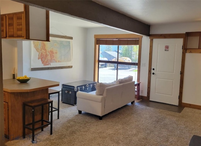 living area featuring light carpet and baseboards