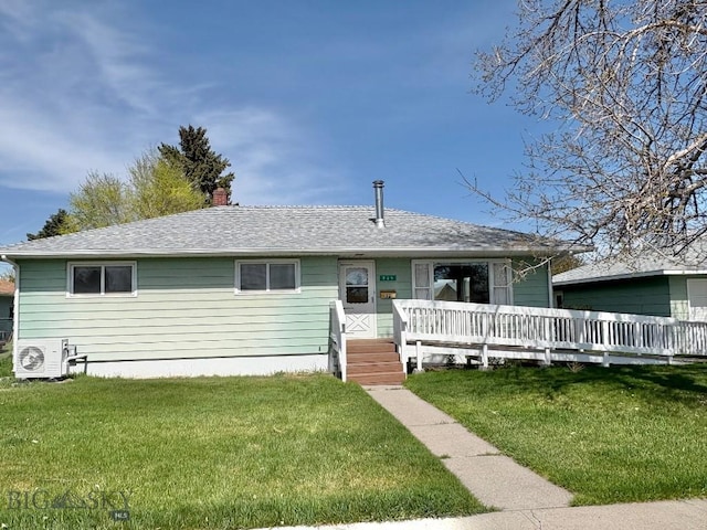 view of front of house featuring a front yard, a chimney, and a shingled roof