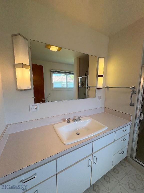 full bath with a shower stall, vanity, and tile patterned flooring