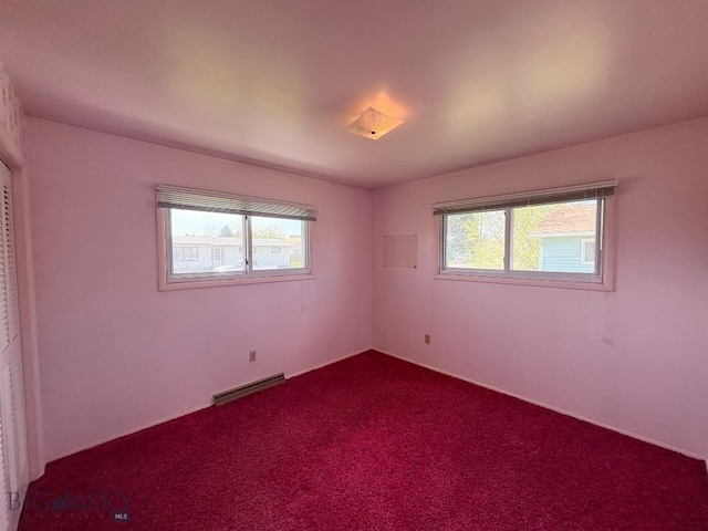 unfurnished room with plenty of natural light and dark colored carpet