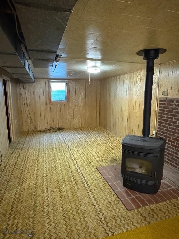 basement featuring a wood stove and wooden walls