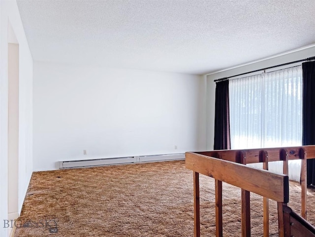 spare room with carpet flooring, baseboard heating, and a textured ceiling