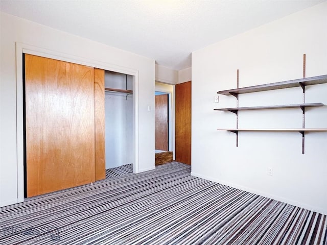 unfurnished bedroom featuring carpet flooring, a closet, and baseboards