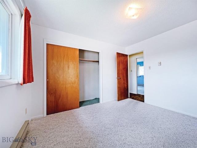 unfurnished bedroom featuring carpet floors, a closet, and a textured ceiling