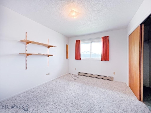 unfurnished bedroom with a baseboard radiator, carpet, a textured ceiling, and a closet