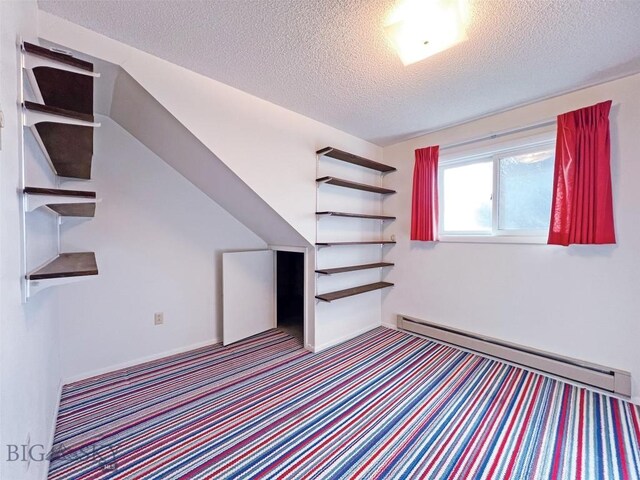 unfurnished bedroom featuring a baseboard radiator, a textured ceiling, and carpet