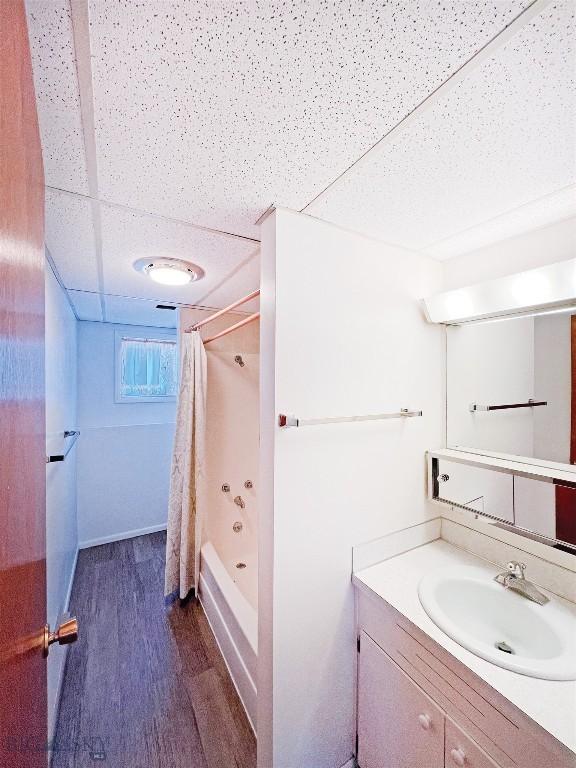full bath with wood finished floors, vanity, and shower / bathtub combination with curtain