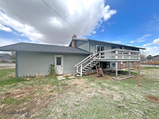 back of house with stairs, a wooden deck, and a chimney