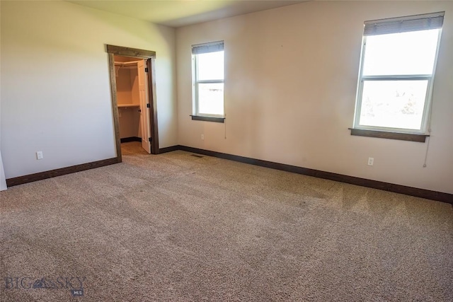 carpeted spare room featuring baseboards