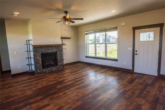 unfurnished living room with a fireplace, a ceiling fan, dark wood-type flooring, baseboards, and recessed lighting
